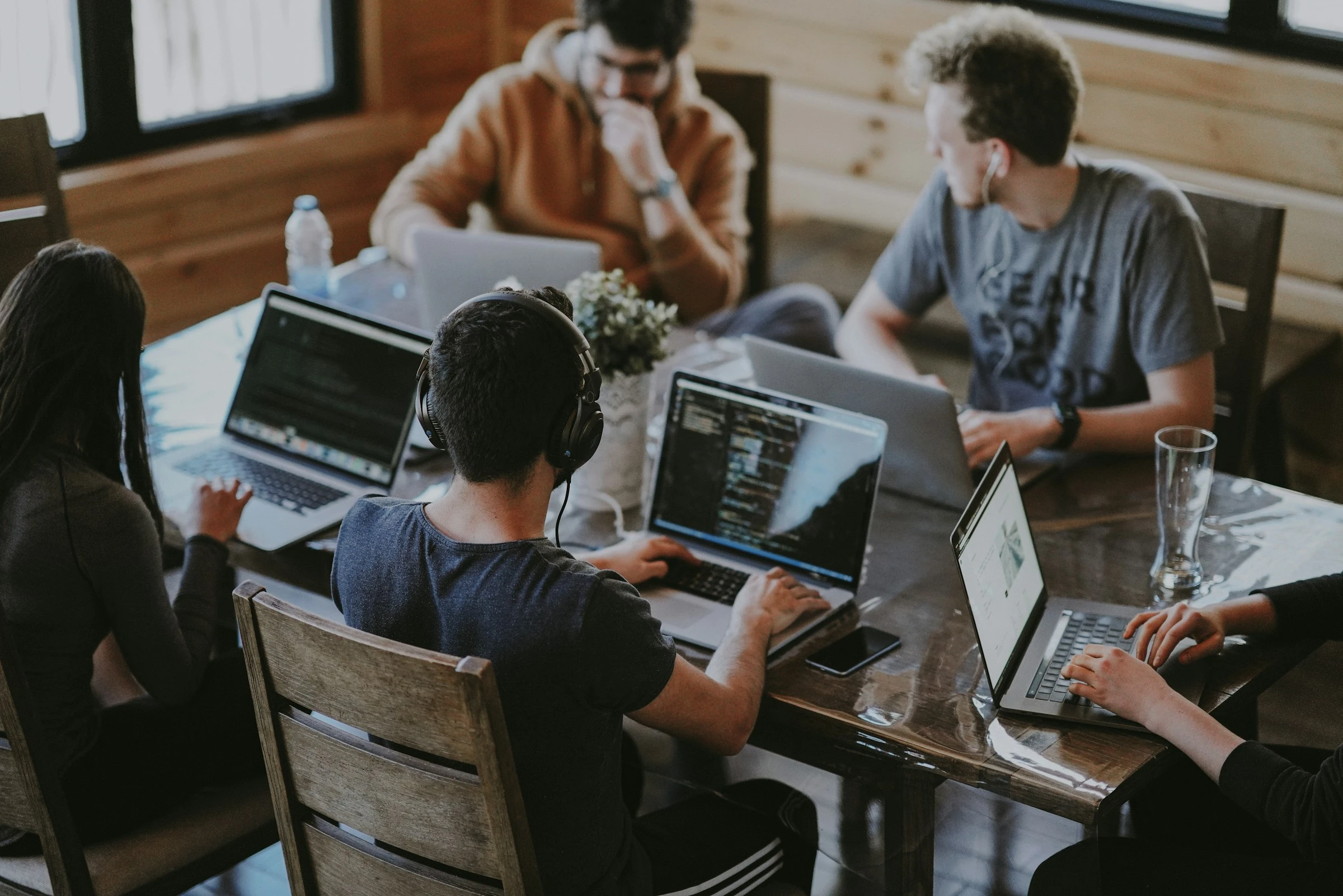 Product team collaborating around laptops in a modern technology office