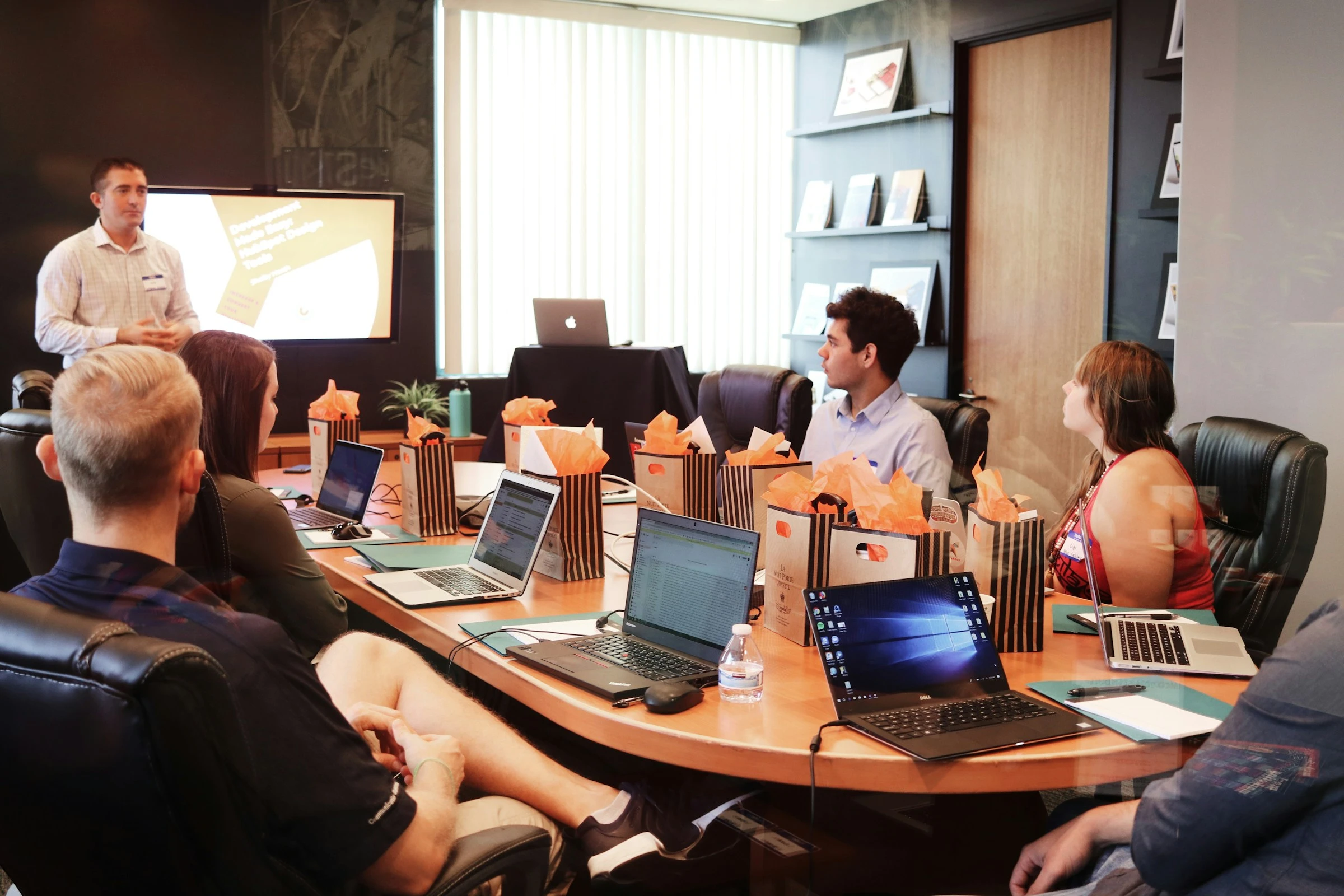 Technology consultants collaborating around a laptop in a modern corporate office